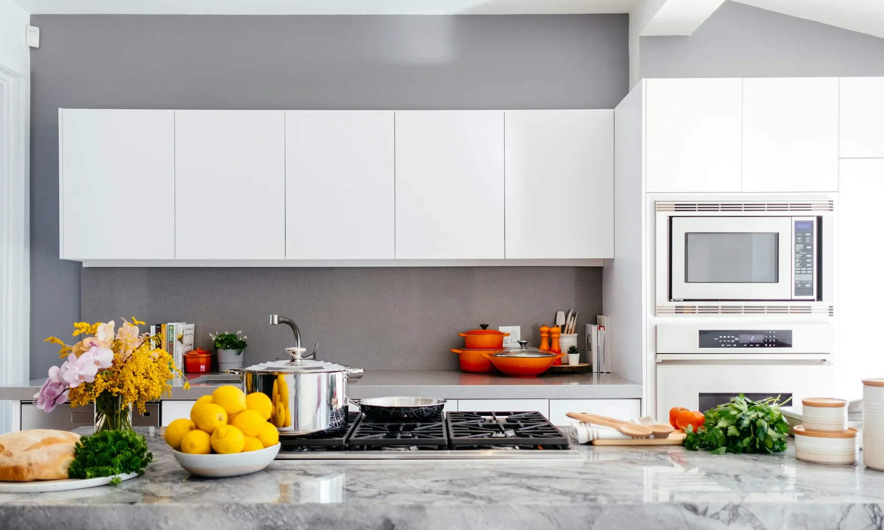 White cabinetry and a marble island in a modern kitchen.